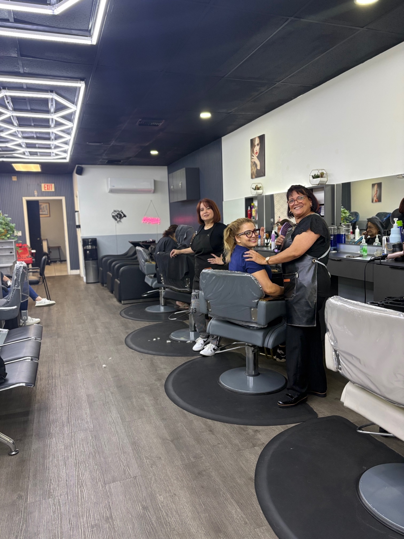 Natalie salon stylists with a client at the hair station
